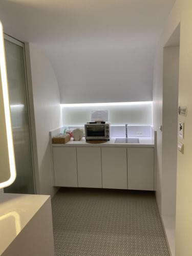 a small kitchen with a sink and a microwave at 16 Post Station Single Tour in Hengchun