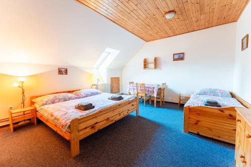 a bedroom with two beds and a table and chairs at Penzion U rybníka in Šumperk