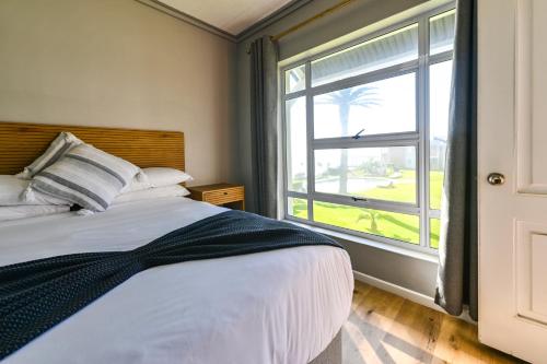 GqeberhaにあるUnit 117 Brookes Hill Suitesのベッドと大きな窓のある寝室