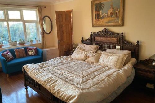 a bedroom with a large bed and a blue chair at Apartment - Sleeps 4 - Parking - Balcony - Garden in High Wycombe