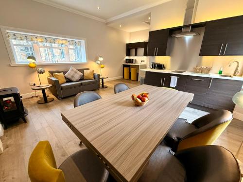 a kitchen and living room with a wooden table and chairs at Court Residence Aparthotel in Linlithgow
