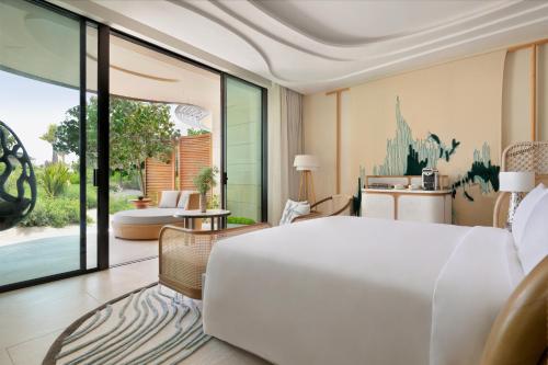 a bedroom with a large white bed and a patio at InterContinental The Red Sea Resort by IHG in Ḩanak