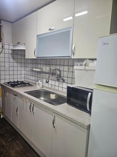 a kitchen with a sink and a refrigerator at k조이스테이 in Pongsan-dong