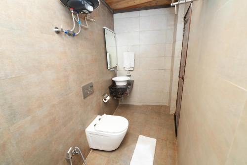 un bagno con un water bianco e uno specchio di Dallas Express Hotel & Restaurant a Mussoorie