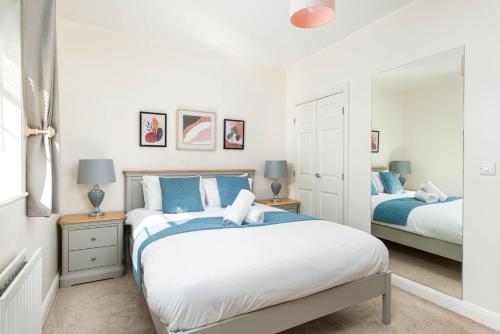 a bedroom with two beds and a mirror at Seaside 2-Bed with Private Parking, Portishead in Portishead