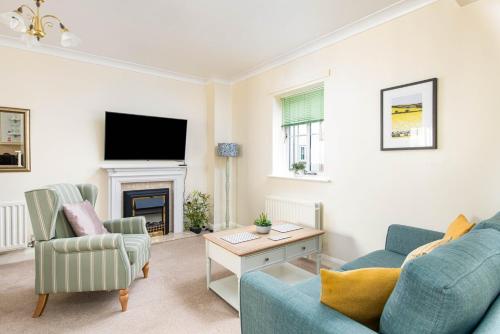 a living room with two blue chairs and a fireplace at Seaside 2-Bed with Private Parking, Portishead in Portishead