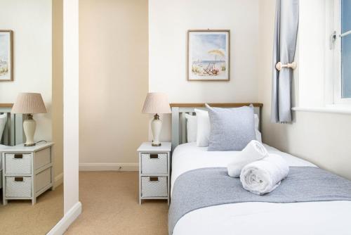 two beds in a room with two lamps and a mirror at Seaside 2-Bed with Private Parking, Portishead in Portishead