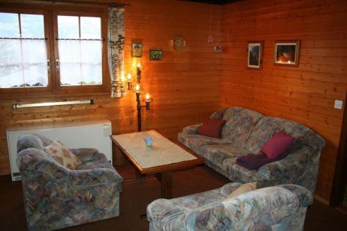 a living room with two couches and a coffee table at Chalet Oase in Susten