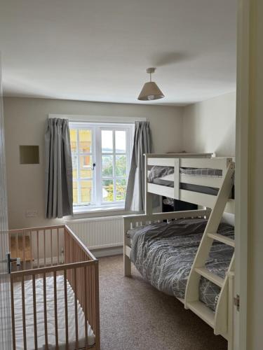 a bedroom with two bunk beds and a window at The annex in Bradninch