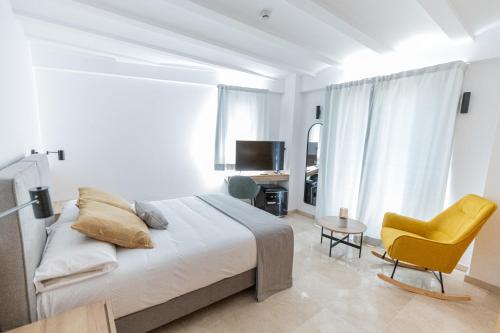 een witte slaapkamer met een bed en een gele stoel bij L'Anxana in Formiche Alto