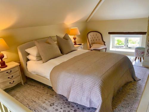 a bedroom with a large bed and a chair at Newly Refurb Cottage, Mile From Blakeney, Village Pub and Restaurant in Langham