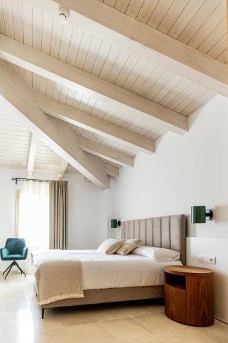 a bedroom with a large bed and wooden ceilings at Hotel L'Anxana - Sólo Adultos in Formiche Alto