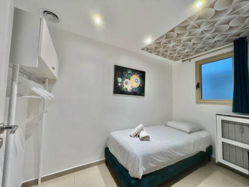 ein weißes Schlafzimmer mit einem Bett und einem Fenster in der Unterkunft Colony 2 in Cannes