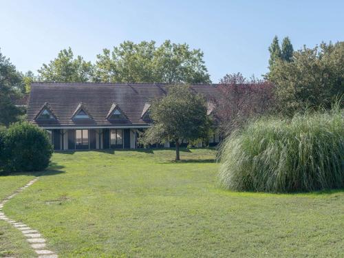 une maison avec un toit en gambrel dans une cour dans l'établissement Mercure Auxerre Autoroute du Soleil, à Appoigny