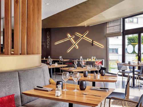 ein Restaurant mit Tischen und Weingläsern an der Wand in der Unterkunft Novotel Marne La Vallée Collégien in Collégien