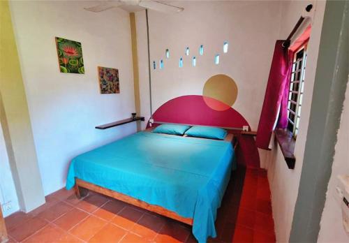 a bedroom with a blue bed in a room at Dragonfly Guesthouse M'Pai Bay in Koh Rong Sanloem