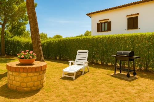 a bbq and a chair and a grill in a yard at Villa Carla accesso al mare privato posto auto riservato in Sperlonga