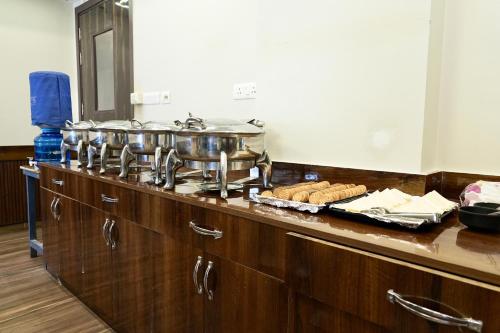 ニューデリーにあるMajesta Stay at Hotel Royal Saffron - Kirti Nagarのカウンターの上に鍋2つとパンが置かれたキッチン