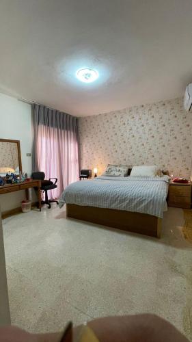 sypialnia z łóżkiem, biurkiem i oknem w obiekcie zainab house w mieście Amman