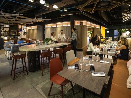 a restaurant with people sitting at tables in a room at Novotel Strasbourg Centre Halles in Strasbourg