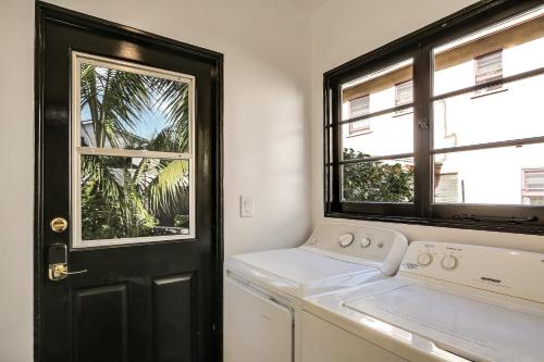 una lavandería blanca con puerta y ventana negra en West Beach Villa 3, en Santa Bárbara