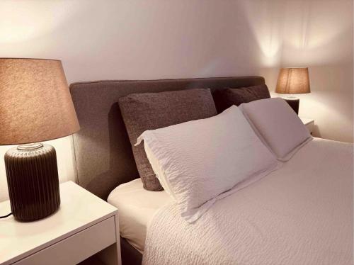 a bedroom with a bed and a nightstand with a lamp at Foresta Living in Mendrisio