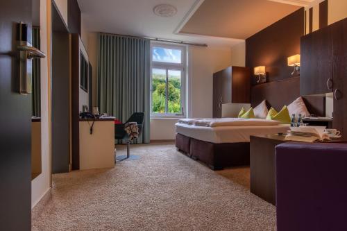 Bad RehburgにあるParkhotel Bad Rehburgのベッドと窓のあるホテルの部屋