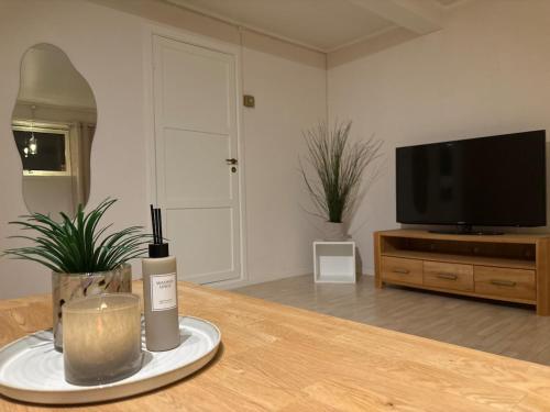a living room with a table with a candle and a television at Tors vei in Alta