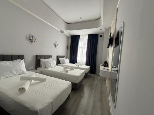 Una habitación de hotel con dos camas y un televisor. en Turkezm Hotel, en Urganch