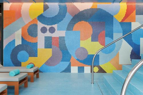 a mural on the wall of a room with stairs at Moxy Alfragide Lisboa in Alfragide