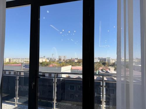 een raam met uitzicht op de stad bij Turkezm Hotel in Urganch