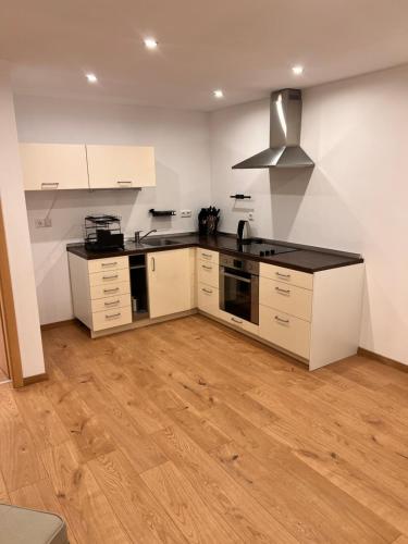 a kitchen with white cabinets and a black counter top at Modern Apartment, nähe, Bodensee und Alb in Dürmentingen