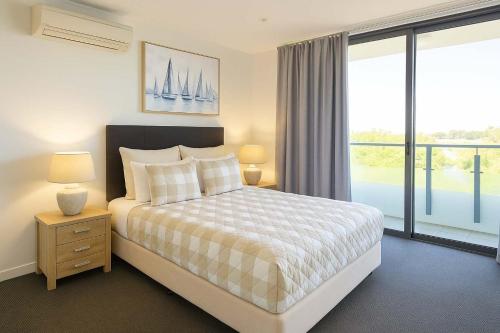 a bedroom with a bed and a large window at Home to Holiday at Central Islington Apartments in Townsville