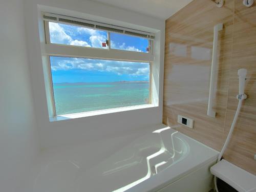a bathroom with a window with a view of the ocean at The feel Kincho cho Seaside villa - sea - / Vacation STAY 26186 in Yaka