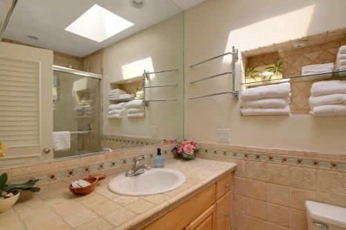 a bathroom with a sink and a mirror at Little Palm Cottage in Santa Barbara