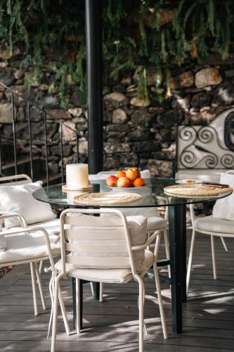 a table with chairs and a table with fruit on it at Villa Wisteria in Funchal