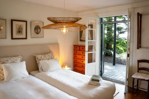 a bedroom with two beds and a door to a patio at Villa Wisteria in Funchal