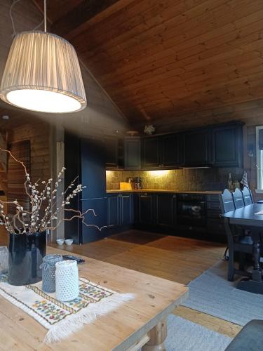 a kitchen with a wooden table and a dining room at Hytte i Myrkdalen in Helgatun