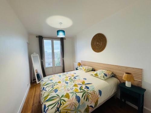 a bedroom with a bed with a floral bedspread at Le Perret -Centre -Authentique -UNESCO in Le Havre