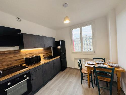 eine Küche mit einer Holztheke und einem Tisch mit Stühlen in der Unterkunft Le Perret -Centre -Authentique -UNESCO in Le Havre