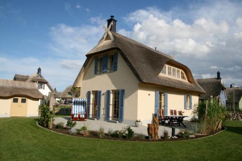 a large white house with a thatched roof at FeHa Ankerplatz mit Sauna und sonniger Terrasse in Parow