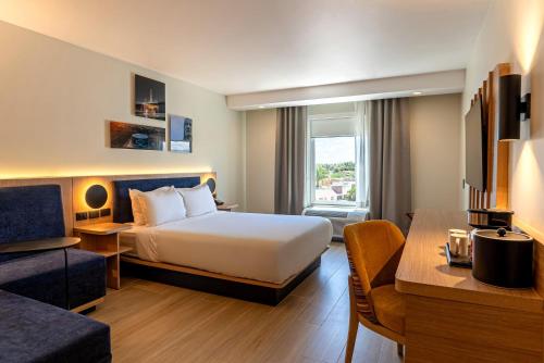 a hotel room with a bed and a couch at Hampton Inn Torreon Airport-Galerias in Torreón