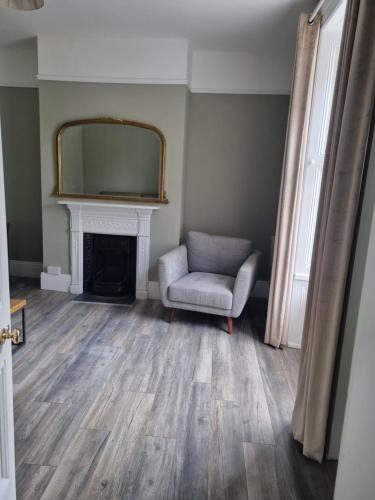 a living room with a chair and a mirror at Moorefield Villa Newbridge in Newbridge