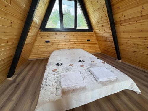 een groot bed in een houten kamer met ramen bij Paradise bungalov in Kocaeli