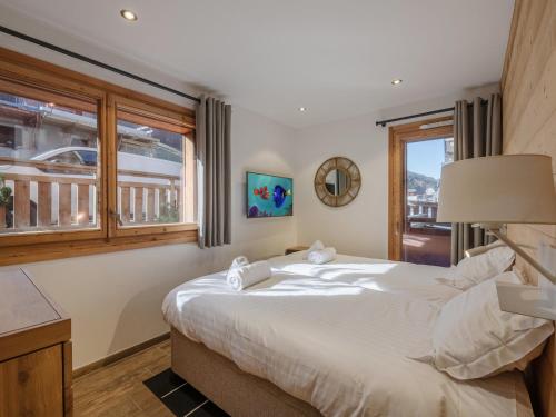 a bedroom with a large bed and a window at Bel appartement moderne, 2 chambres, au centre de Morzine, proche des pistes, parking et wifi - FR-1-754-87 in Morzine