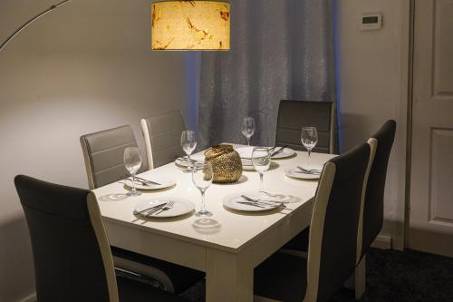 a dining room table with wine glasses on it at Modern 2-Bed House Free Parking Contractors & Families Friendly Rotherham in Park Gate