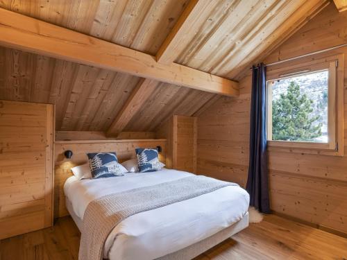 a bedroom with a bed in a wooden cabin at Chalet neuf 10 pers, charme et confort à Serre Chevalier - FR-1-808-20 in Le Monêtier-les-Bains