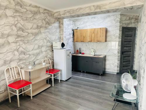 a kitchen with a refrigerator and a table with chairs at Аэропорт apartments in Pokrovka