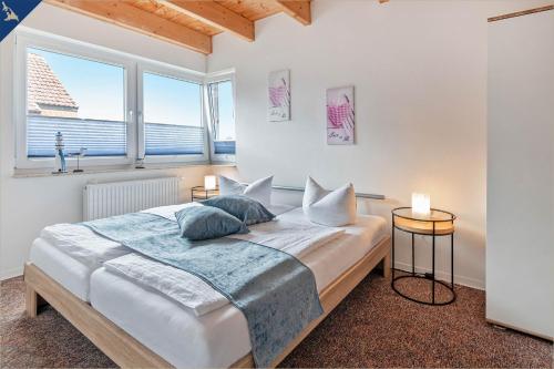 Un dormitorio con una cama grande y dos ventanas. en Kimpi 2, en Ostseebad Koserow