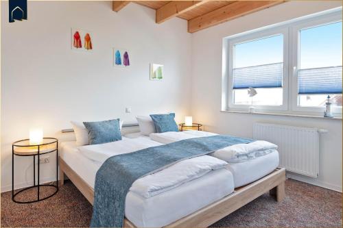 ein Schlafzimmer mit einem großen Bett und zwei Fenstern in der Unterkunft Kimpi 3 in Ostseebad Koserow